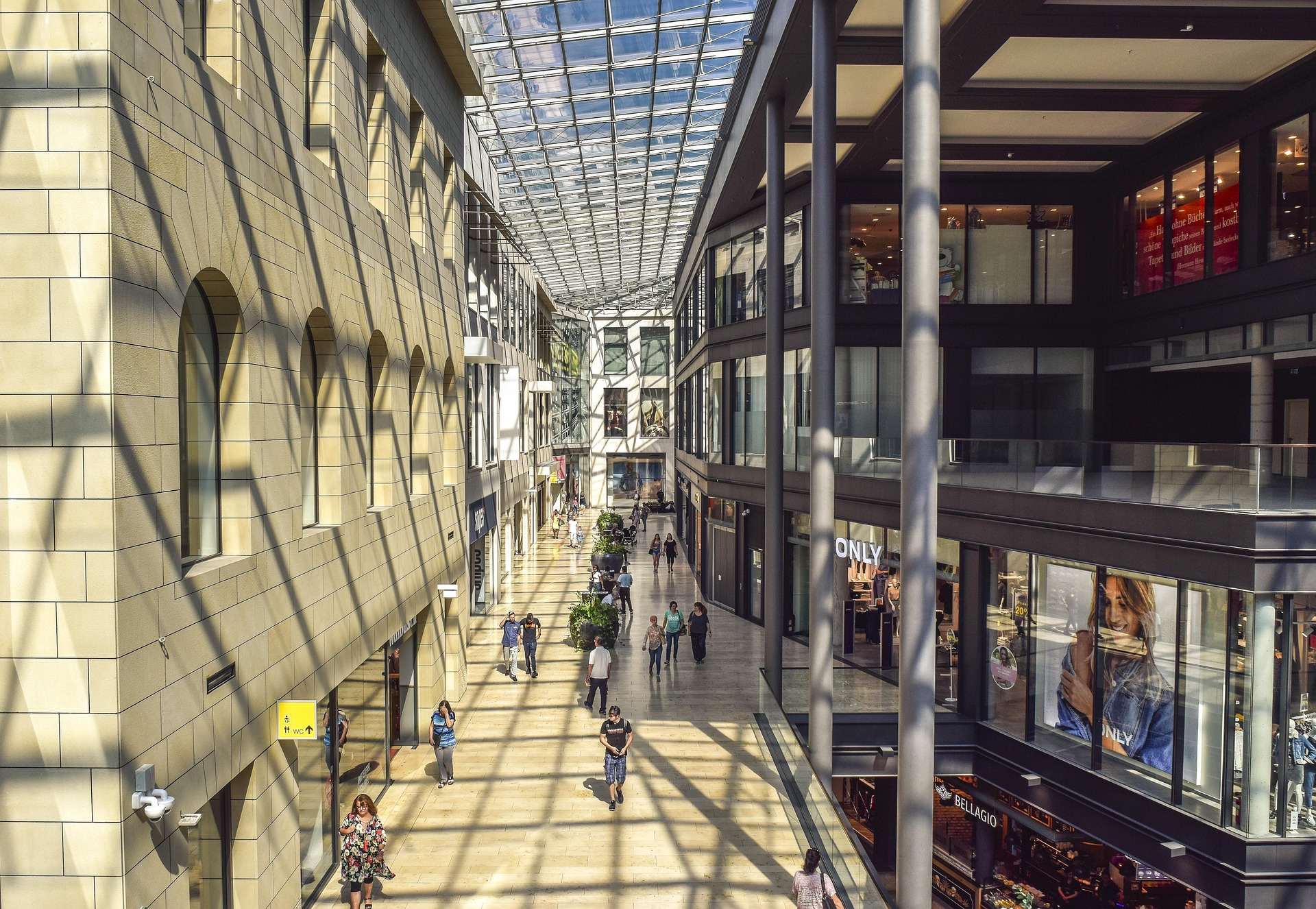 Galeria comercial com lojas e circulação de pessoas