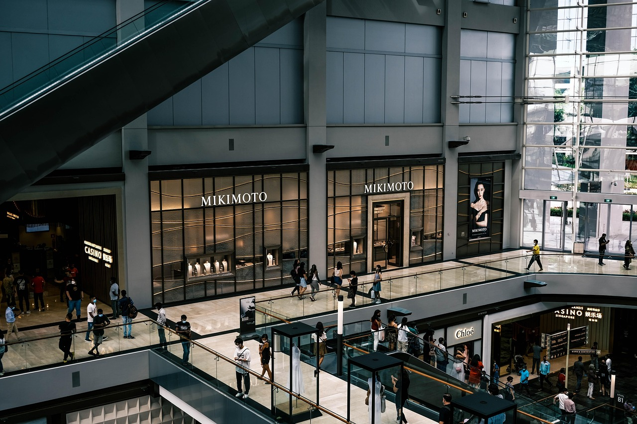 Interior de shopping center com lojas e circulação de pessoas